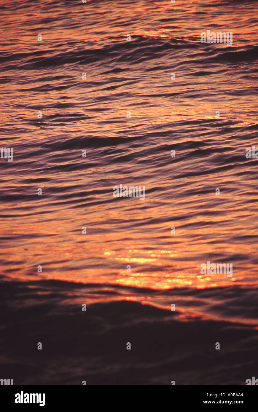 Das Meer spiegelt die Farben des Sonnenuntergangs. Stockfoto