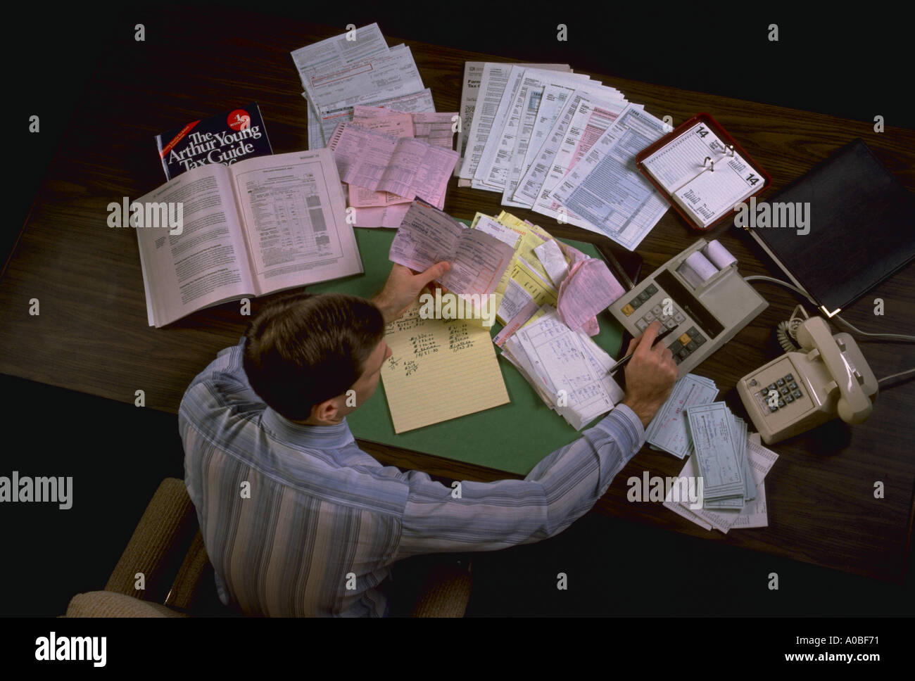 Mann befreit arbeiten am Schreibtisch, die Berechnung von Steuern AB79079 Stockfoto