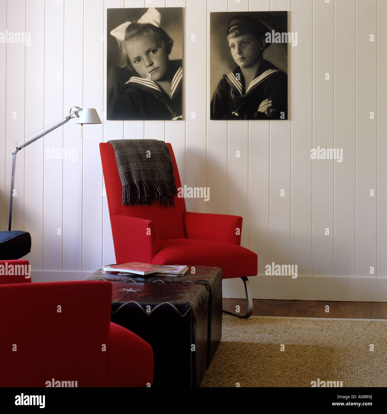 Wohnzimmer mit roten Sesseln und Vintage Sepia Fotografien an Wand Stockfoto