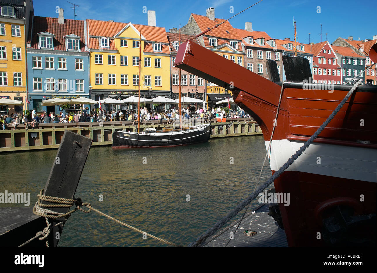 Festgemachten Segelbooten und überfüllten Kai Café-Terrassen, Nyhavn, Kopenhagen, Dänemark Stockfoto