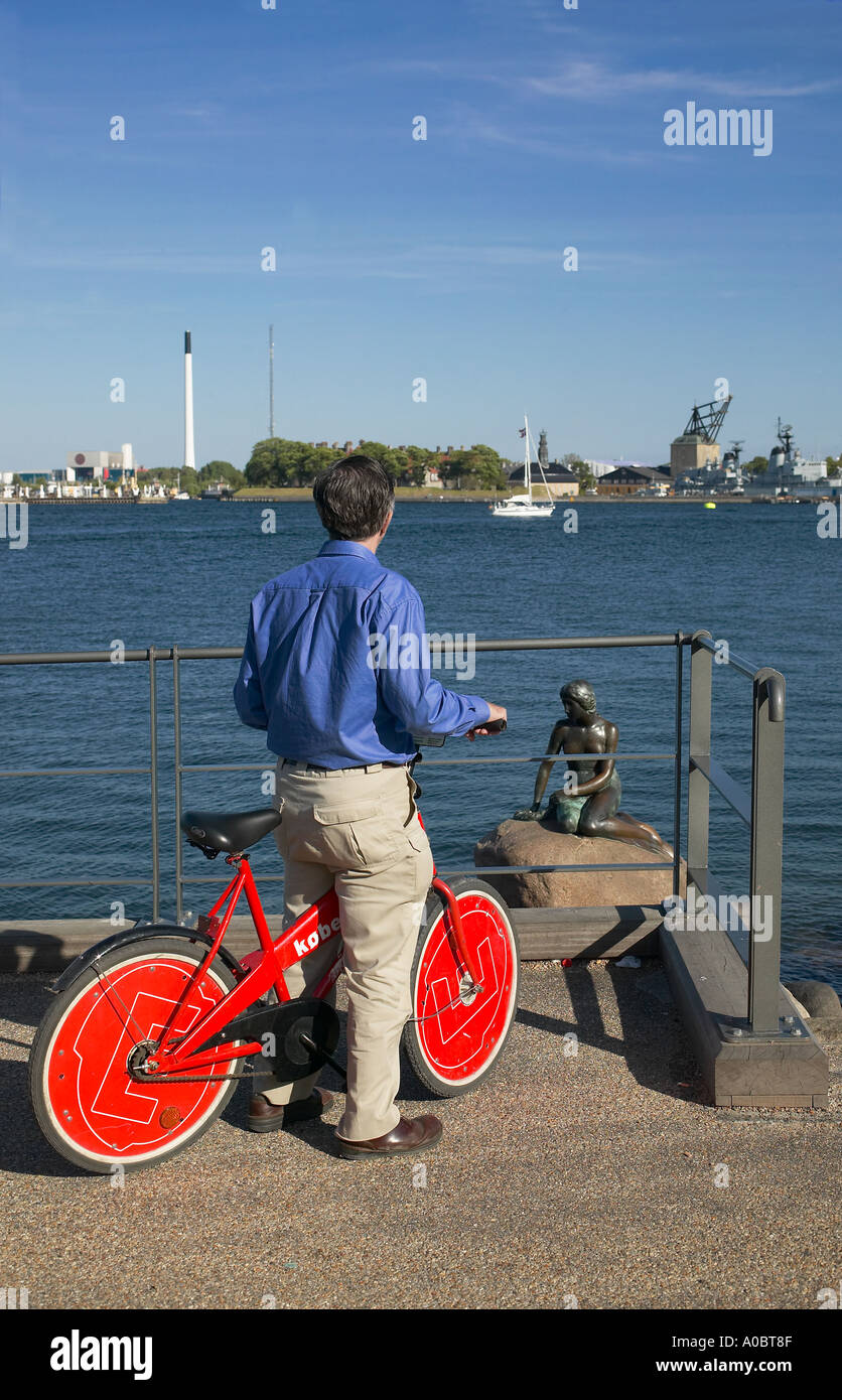 Tourist mit rotem Leihfahrrad mit Blick auf die kleine Meerjungfrau Statue, Kopenhagen, Dänemark, Europa Stockfoto