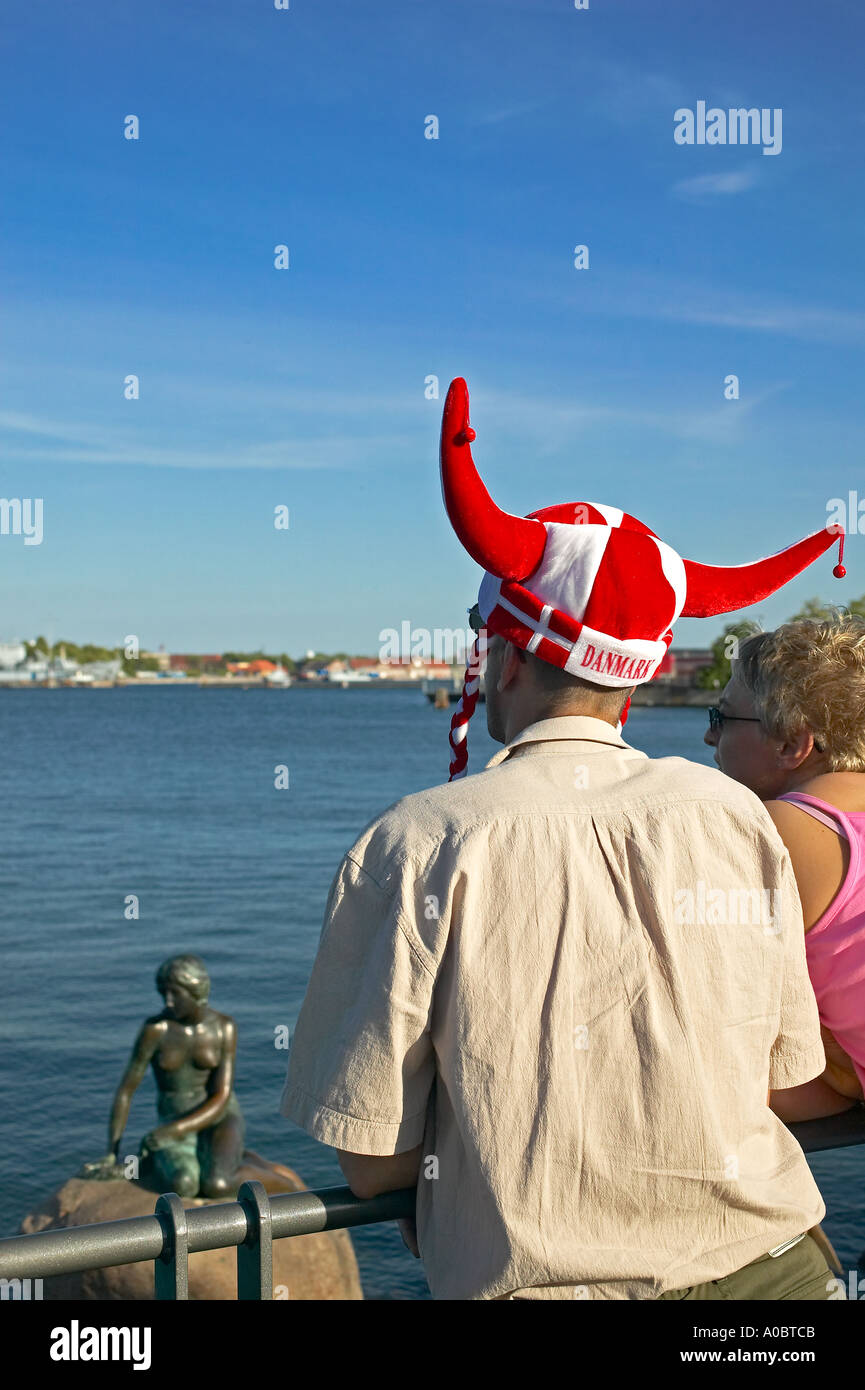 Tourist mit Rot gehörnte Kappe an der Statue der Kleinen Meerjungfrau, Kopenhagen, Dänemark, Europa Stockfoto