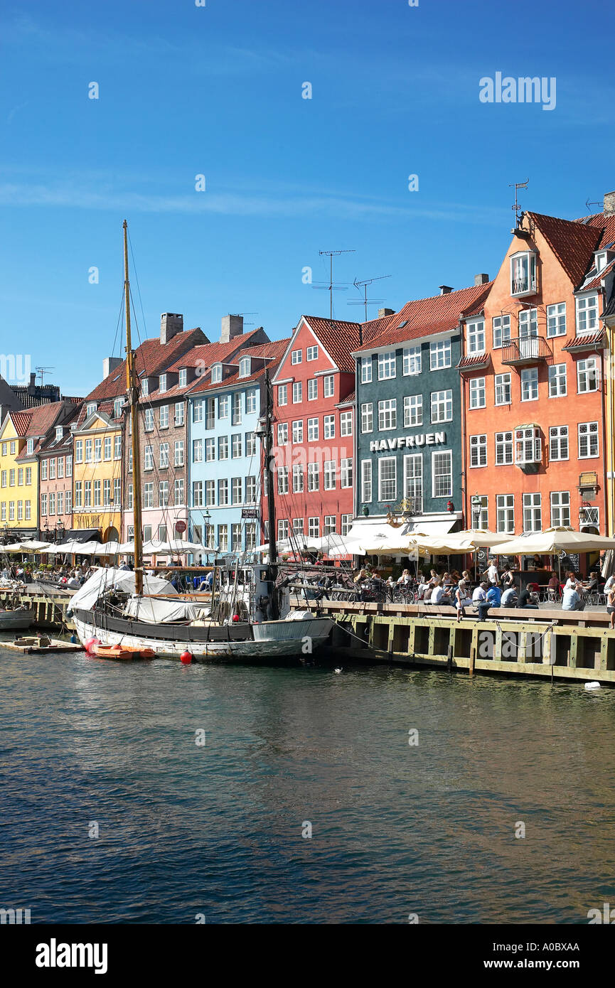 Festgemachten Segelboot und überfüllten Kai Café-Terrassen, Nyhavn, Kopenhagen, Dänemark Stockfoto