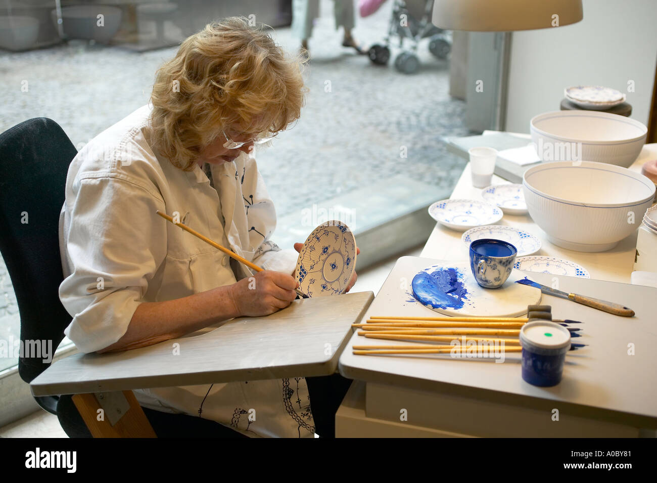 Frau malt eine Tafel an der "Royal Copenhagen Porzellan" FABRIKLADEN, Kopenhagen, Dänemark Stockfoto