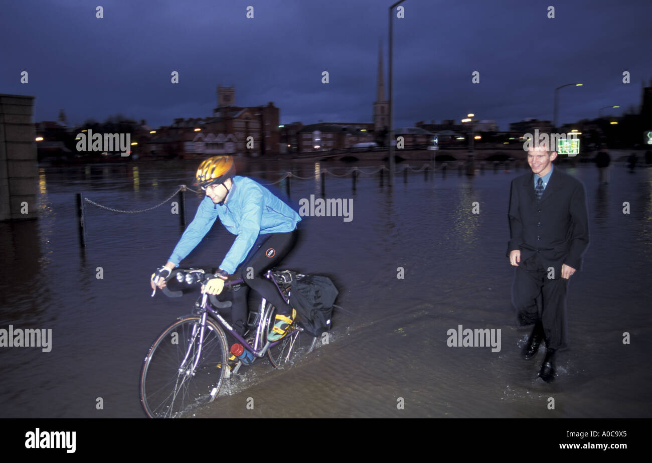 Pendler Wandern und Radfahren nach Hause durch Überschwemmungen im Zentrum von Worcester nach Stadt Überschwemmungen England Stockfoto