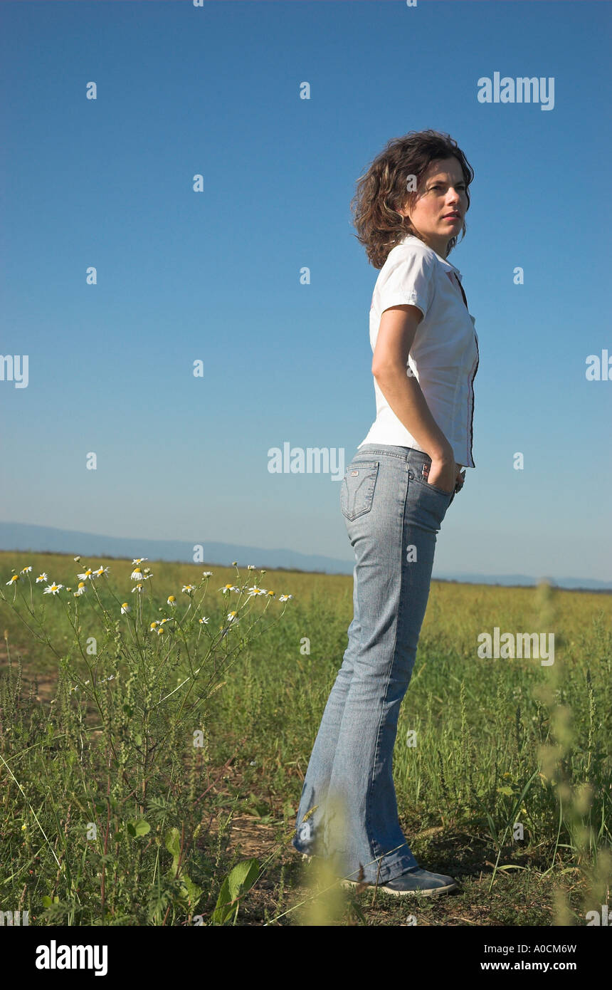 Junge Frau trägt Freizeitkleidung stehen im Feld wegschauen Stockfoto