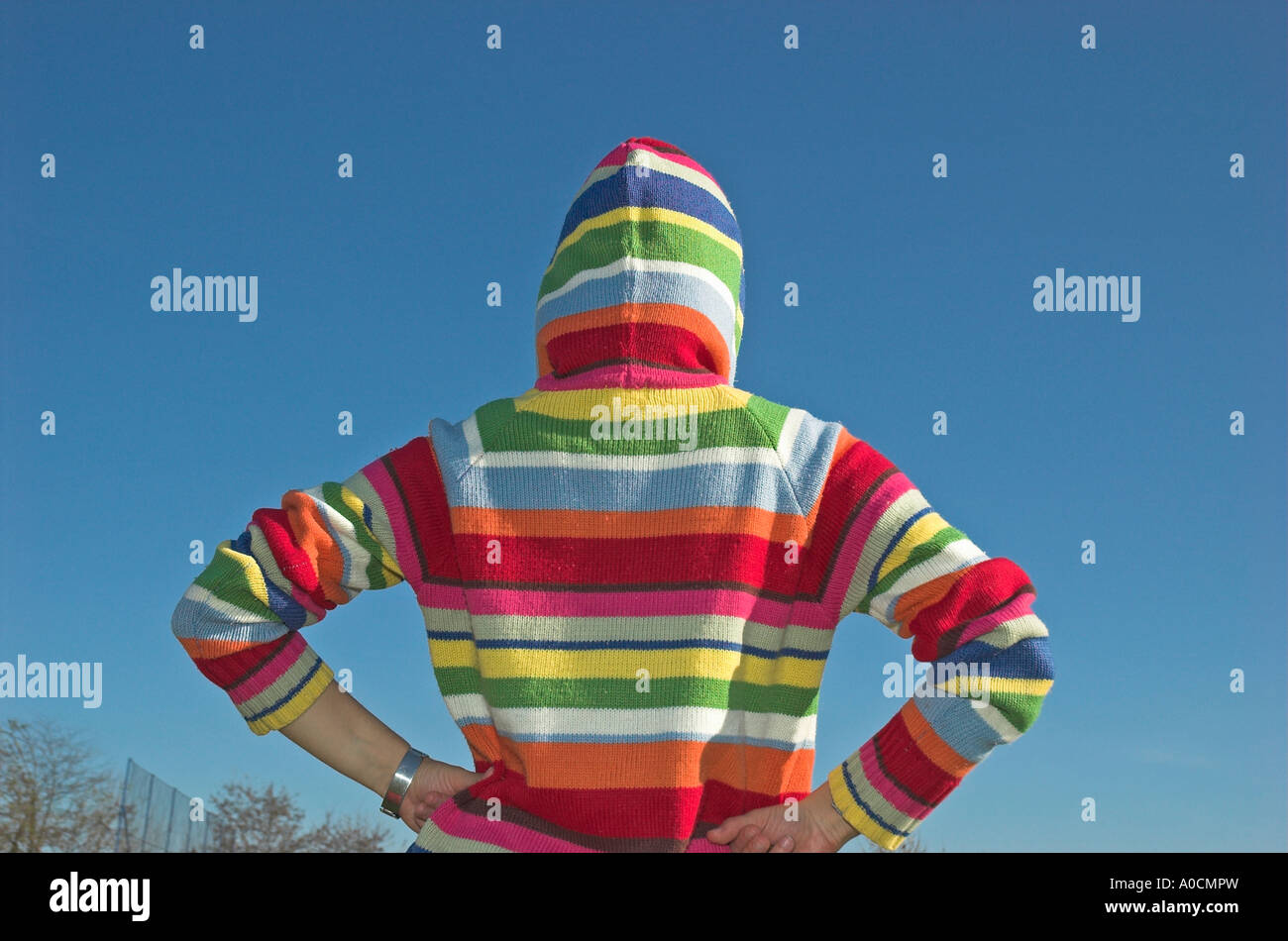 Junge Frau trägt Kapuzensweater stehen im freien Rückansicht Stockfoto