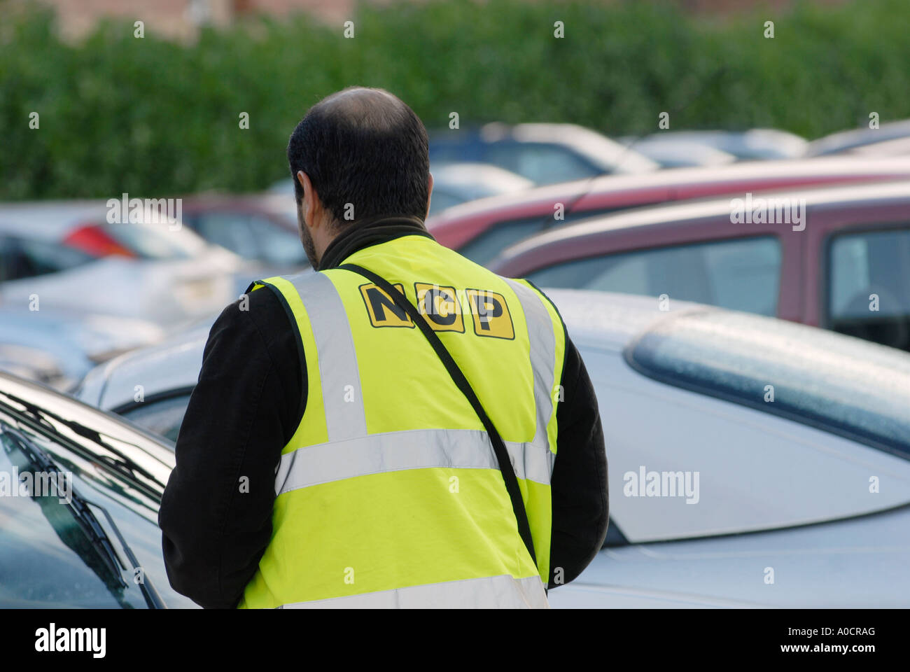 NCP-Parkplatzwächter, der Tickets auf einem Parkplatz in England abcheckt. Stockfoto