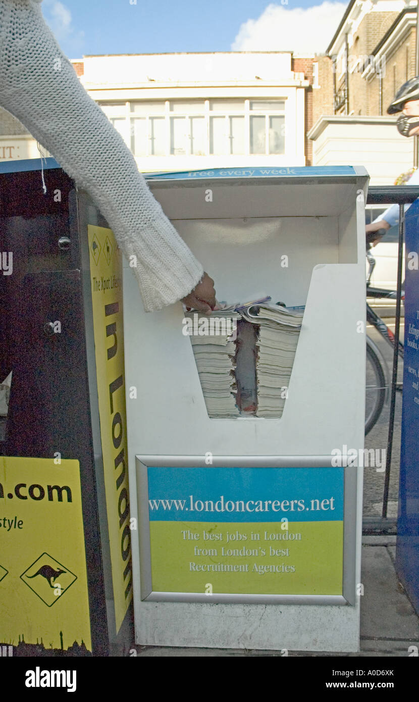 Hand nehmen kostenlose Zeitung vom Stand Highbury Corner London UK Stockfoto