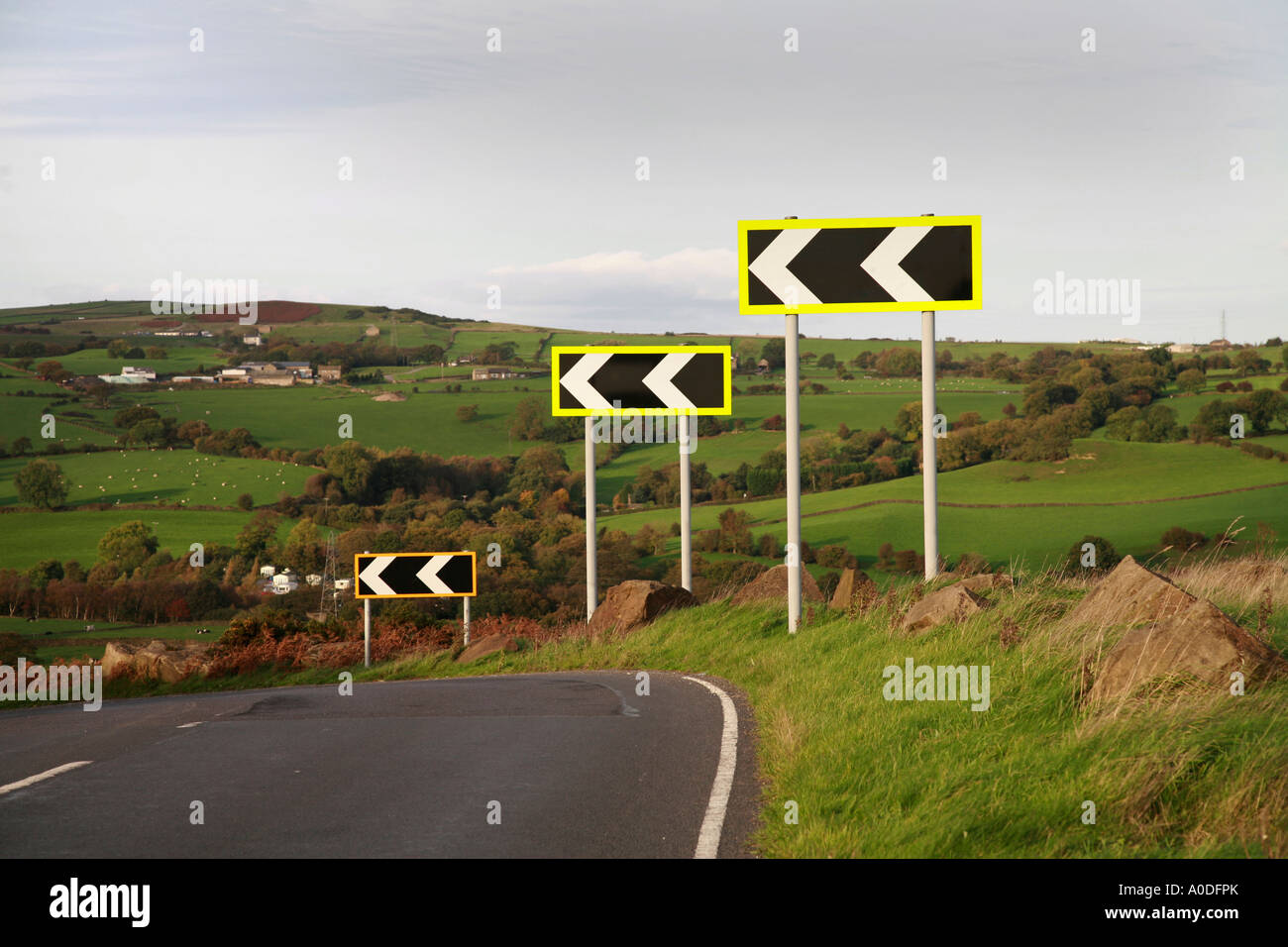 Straße Richtung Chevron Zeichen an der linken Ecke, in Yorkshire Stockfoto