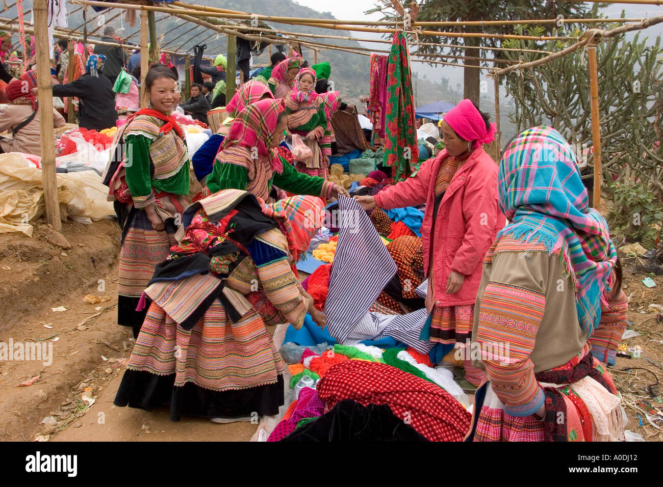 Vietnam kann Cau Flower Hmong Hilltribe Marktfrauen tragen Tracht am Markt stall Verkauf gemustertem Stoff Stockfoto