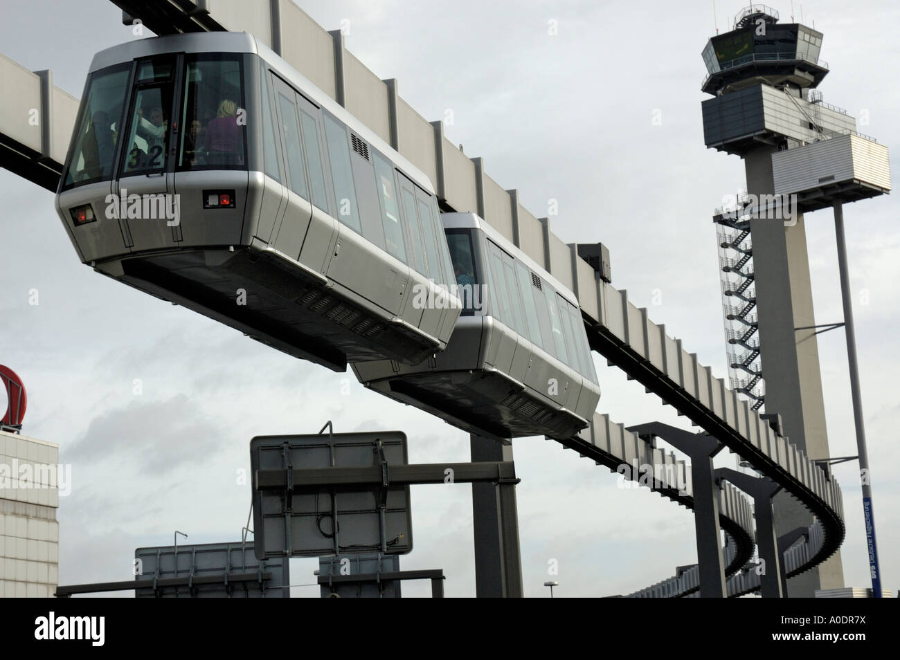 Skytrain, Flughafen Düsseldorf International, Deutschland. Abflug mit Flug Kontrollturm im Hintergrund. Stockfoto