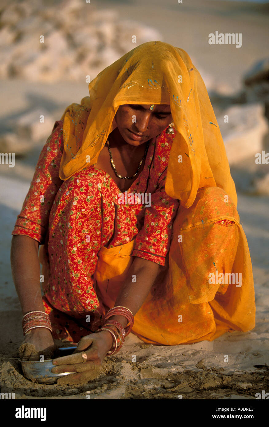 Bhil indigene Frau beim Abwasch mit Sand Dürre und Wüste überleben Barjarsar Rajasthan Indien Stockfoto