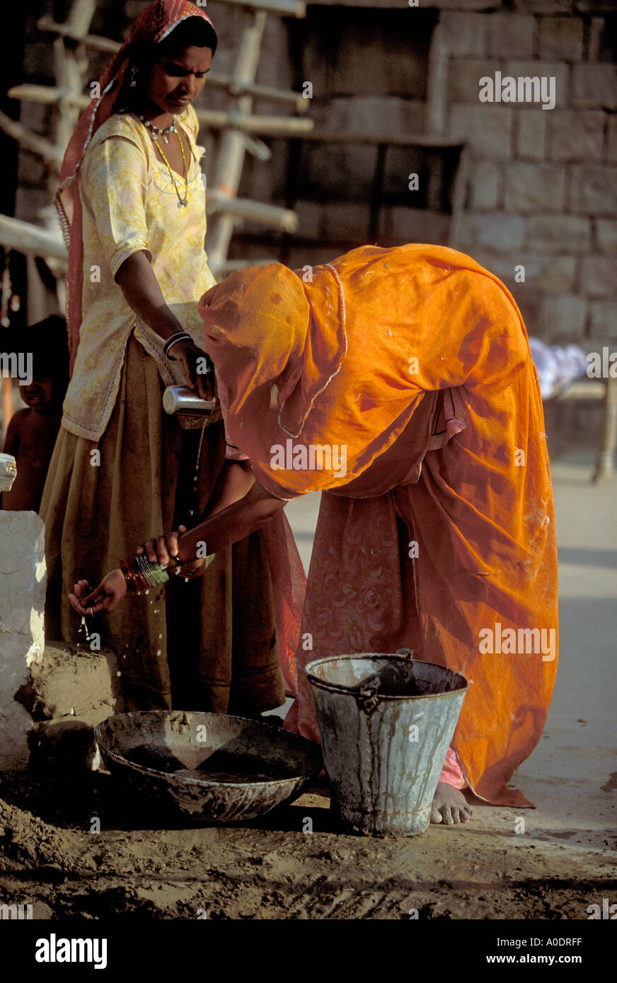 Bhil indigene Frauen während einer Dürre Barjarsar Rajasthan Wüste Indien sparsam waschen Stockfoto