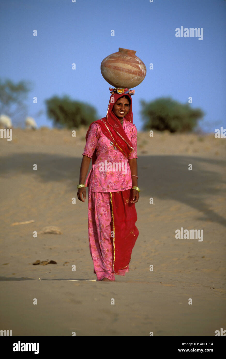 Bhil indigene Frau mit Krügen Wasser auf ihrem Kopf Wüste überleben Rajasthan Indien Stockfoto