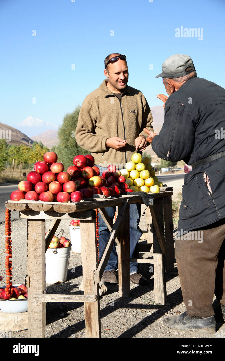 Touristen kaufen Äpfel von Straße Seite Verkäufer mit Berg Ararat im Hintergrund. Armenien, Südwest-Asien Stockfoto