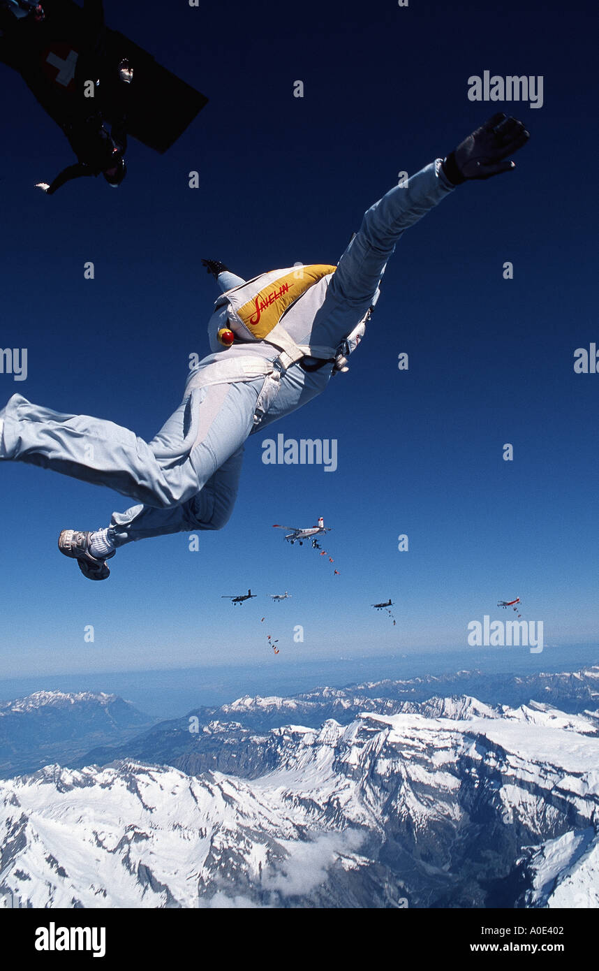 Fallschirmspringer beenden eine Multi-Flugzeug-Formation über die Schweizer Alpen Stockfoto