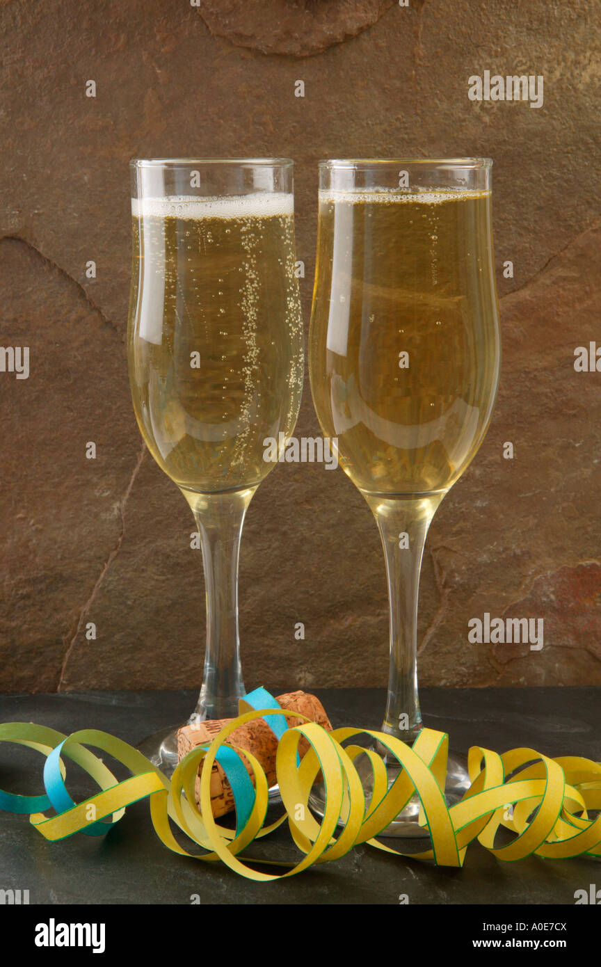Gläser mit Champagner Luftschlangen und Kork auf Schiefer Stockfoto
