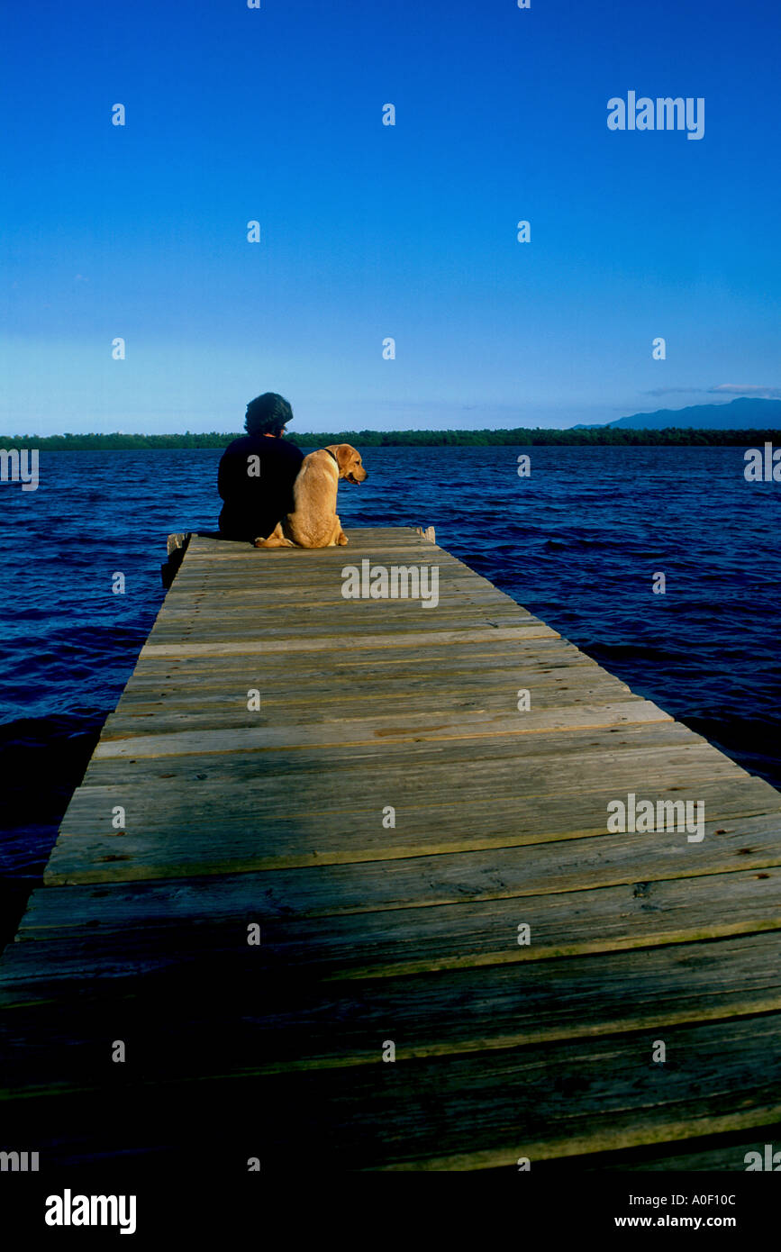 Frau und ihr Welpe sitzt auf dock Stockfoto