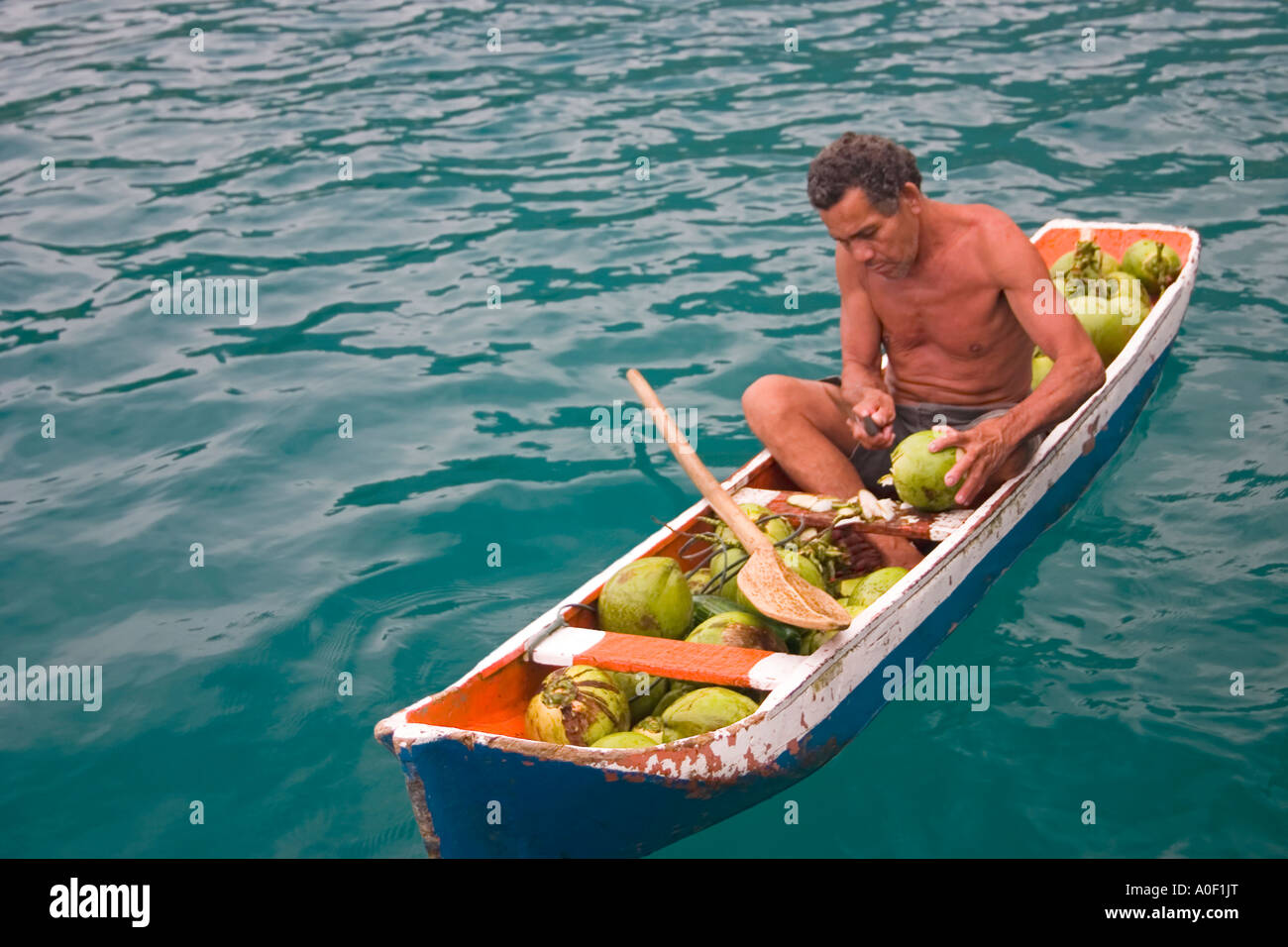 Mann, schneiden und verkauft Kokosnüsse in einem Kanu, Angra Dos Reis, Bundesstaat Rio De Janeiro, Brasilien Stockfoto