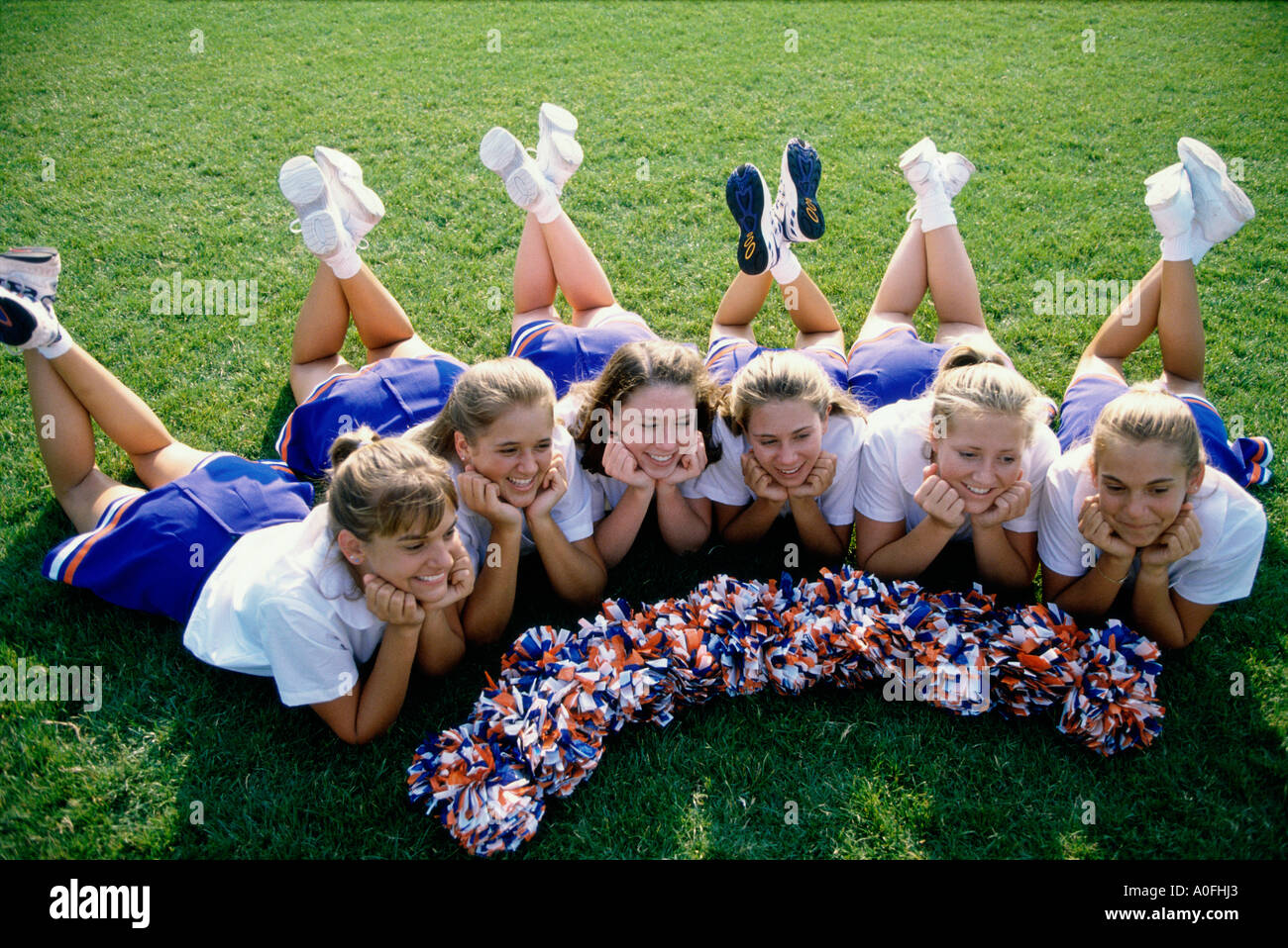 Erhöhte Ansicht von Cheerleadern auf einer Wiese liegend Stockfoto