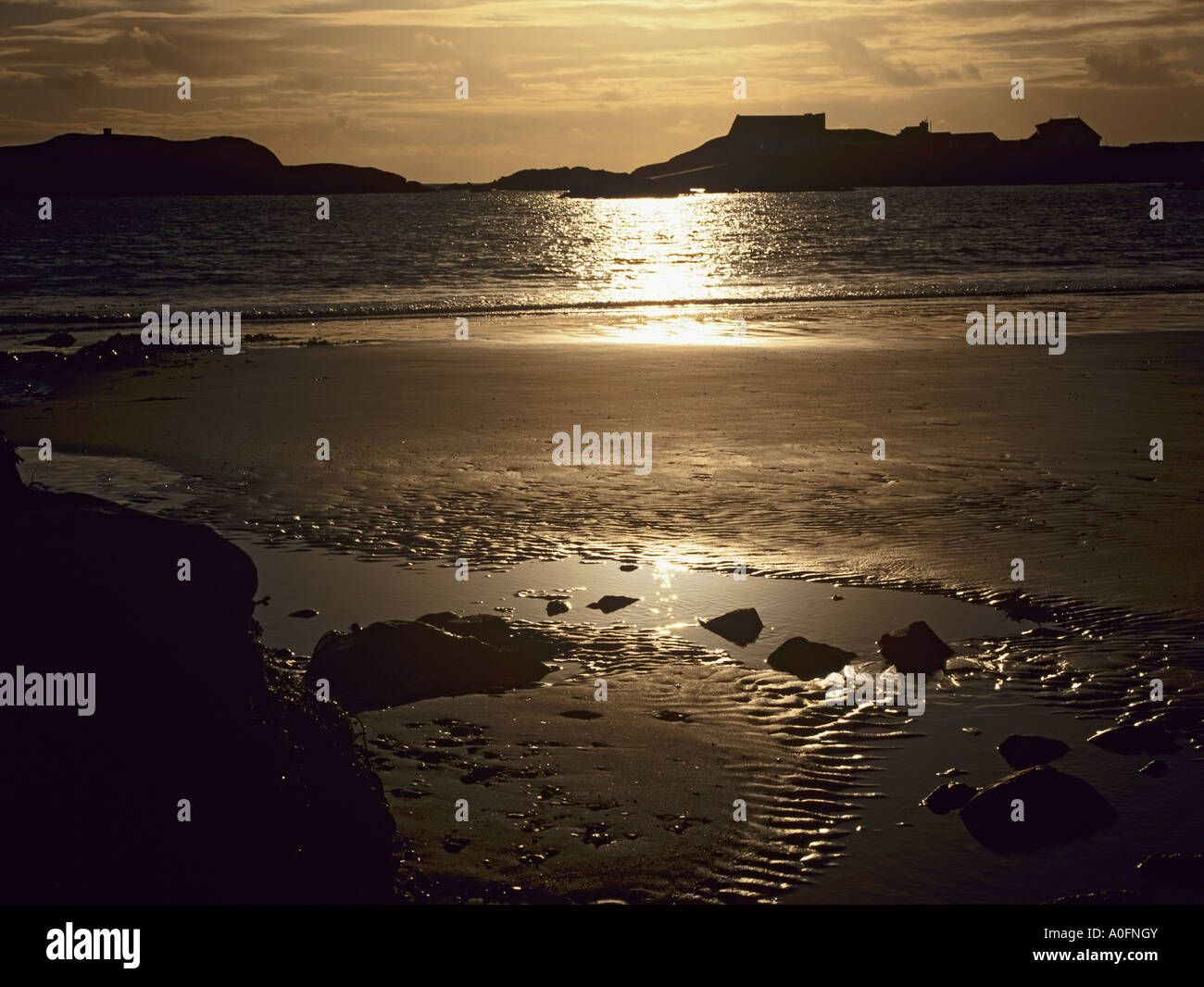 ISLE OF ANGLESEY NORTH WALES UK gewellt Januar der Sonnenuntergang in nassen widerspiegelt Sand und das Meer Stockfoto