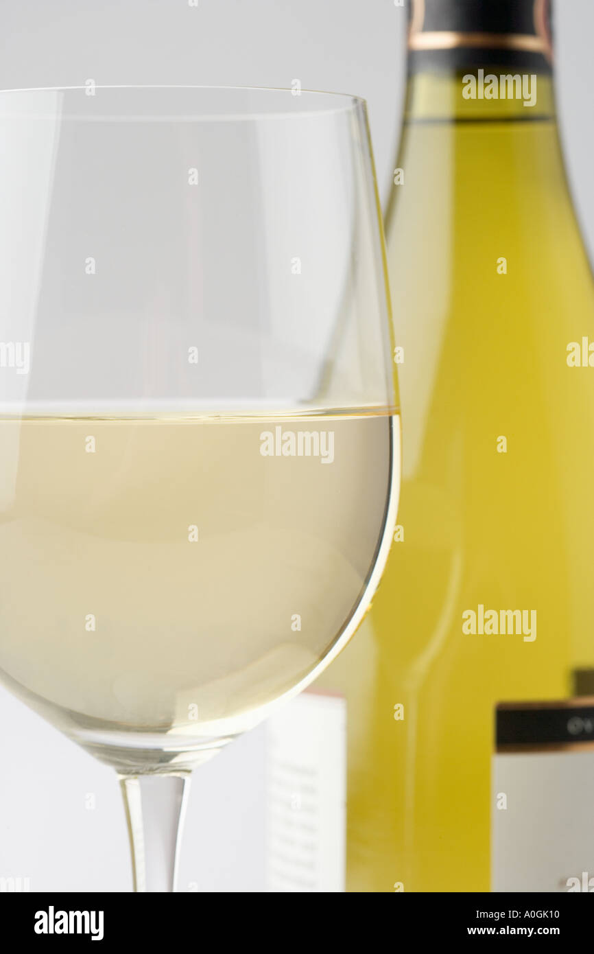 Glas Weißwein mit Flasche Stockfoto