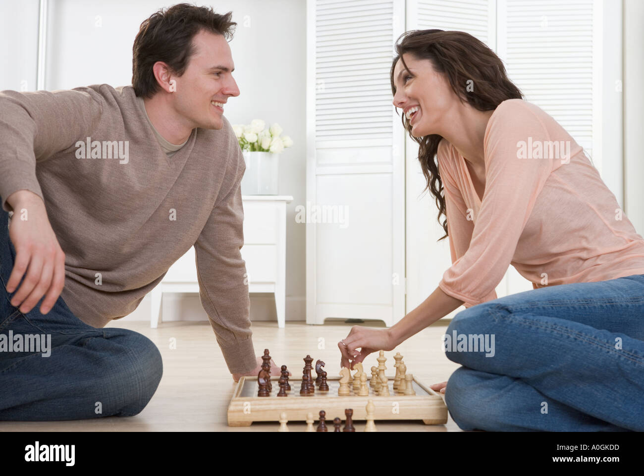 Lächelnde paar spielt Schach Stockfoto