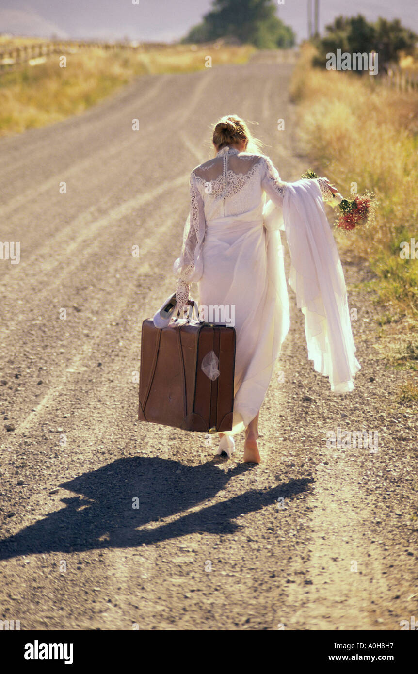 Junge Braut tragen eines Koffers walking im freien Stockfoto