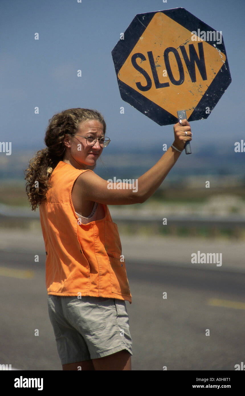 Weibliche Bauarbeiter mit einem Schild Warnung Stockfoto