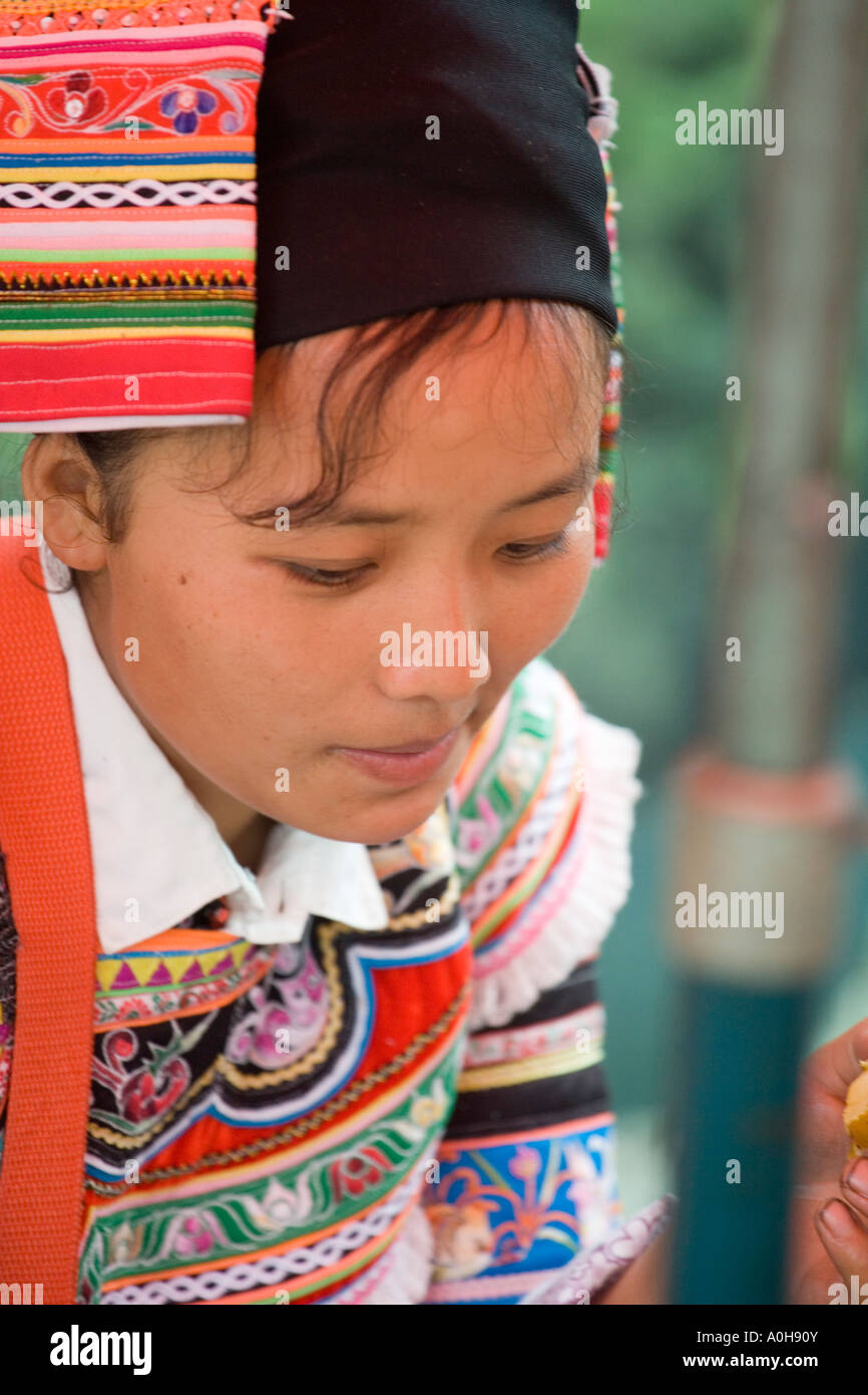 Junge chinesische Volksgruppe Frau genießen etwas Obst, Shengcun Dorfmarkt, Yuanyang, Yunnan, China Stockfoto