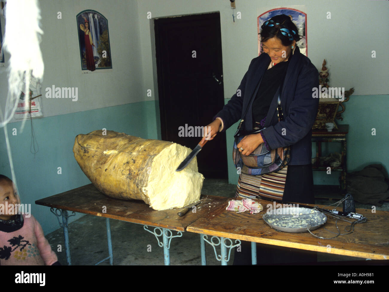 Tibetische Frau verkaufen Yak Butter von einer großen Rolle in Sackleinen enthalten. Tibet. Stockfoto