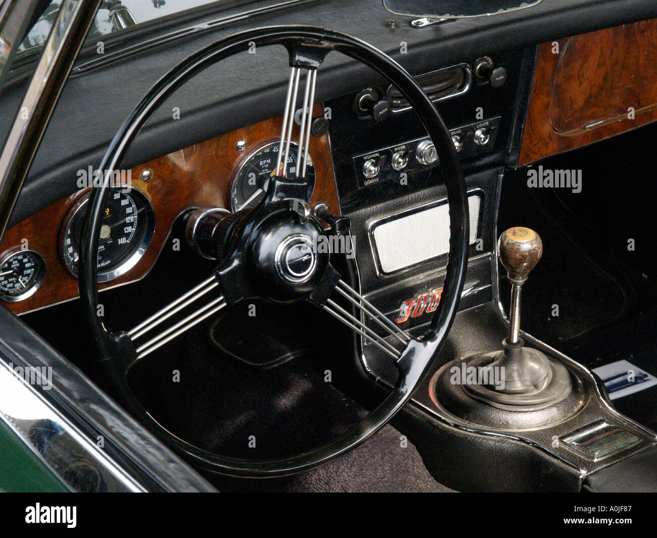 Innenraum eines Austin Healey 3000 mk3 klassischen Sportwagens mit gefederten Lenkrad und Armaturenbrett aus Holz Stockfoto