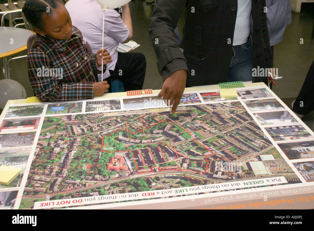 Ein Mann und ein junges Mädchen untersuchen eine Karte mit einer Großsiedlung im Rahmen einer öffentlichen Konsultation zu das Anwesen, Lewisham regenerieren. Stockfoto