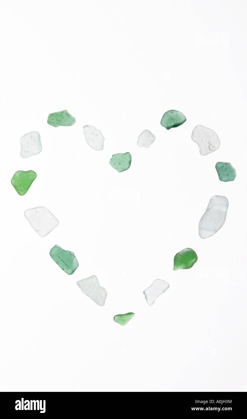 Eine Herzform gemacht mit Rücken leuchtet klar und grüne Glasscherben gewaschen durch das Meer mit einem weißen Hintergrund. Stockfoto