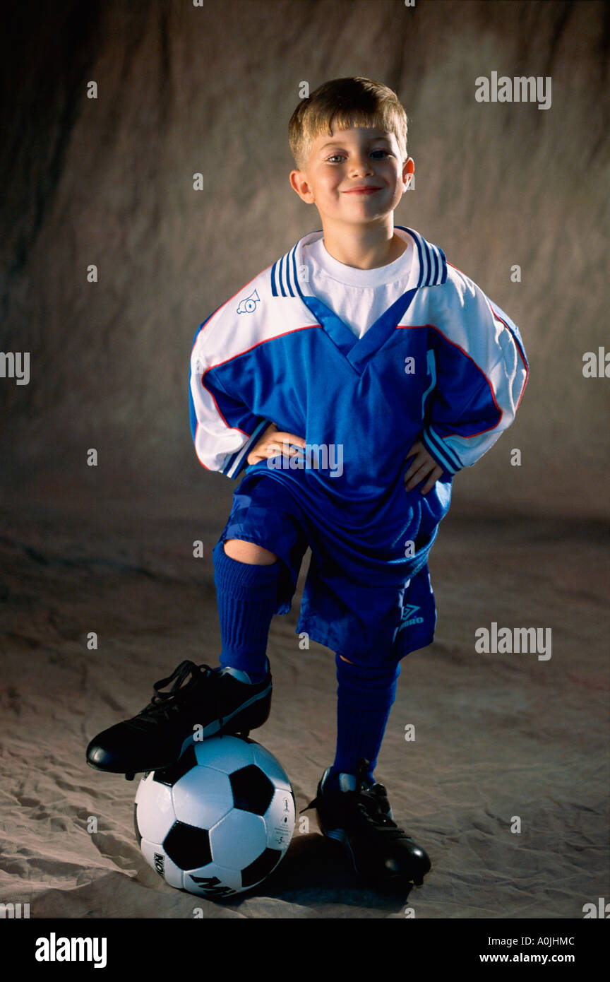 Bildnis eines Knaben mit seinem Fuß auf einem Fußball stehen Stockfoto