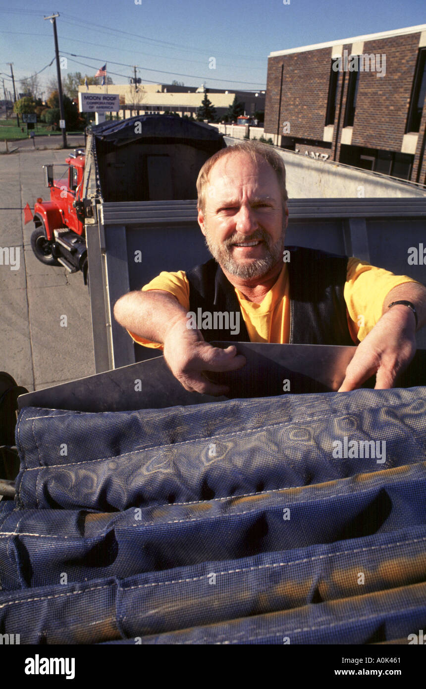Fahrer mit deformierten Händen bedient doppelte Sattelzug Kies Stockfoto