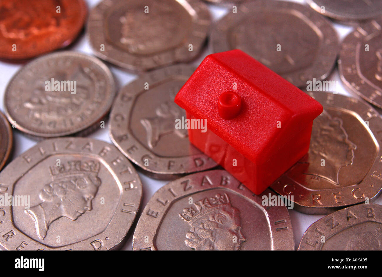 Ein Monolopy Haus auf Münzen zu Haus-Preis und Zinssatz-Änderungen zu veranschaulichen Stockfoto