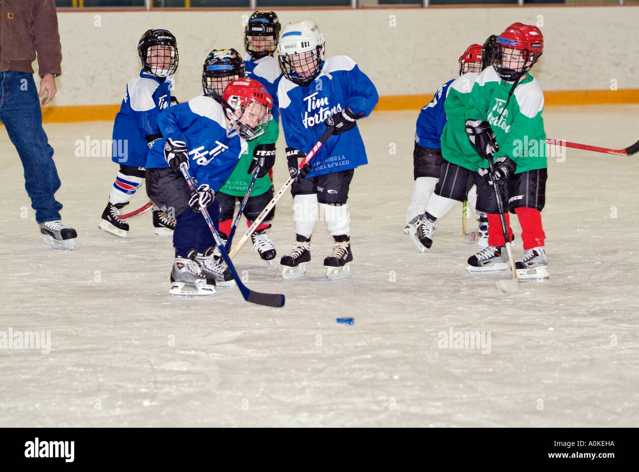 5 Jahre alten Jungen und Mädchen sind die Grundlagen der Eishockey zu spielen lernen. Stockfoto