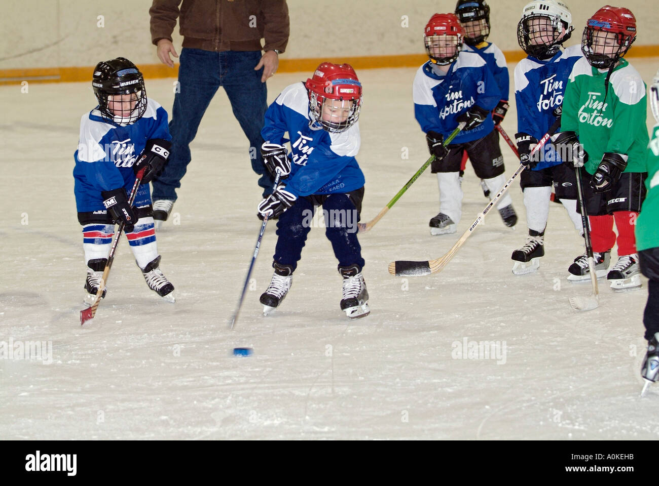 5 Jahre alten Jungen und Mädchen sind die Grundlagen der Eishockey zu spielen lernen. Stockfoto