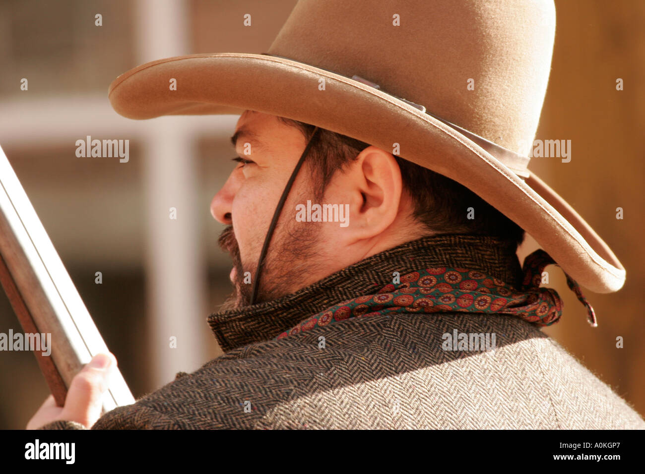 Ein Cowboy mit einem Gewehr ist durch die Stadt Fuß. Stockfoto