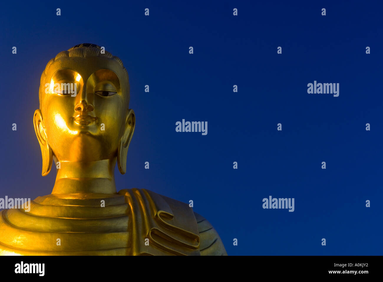 Goldene Statue des Buddha vor einem blauen Himmelshintergrund Asien Stockfoto