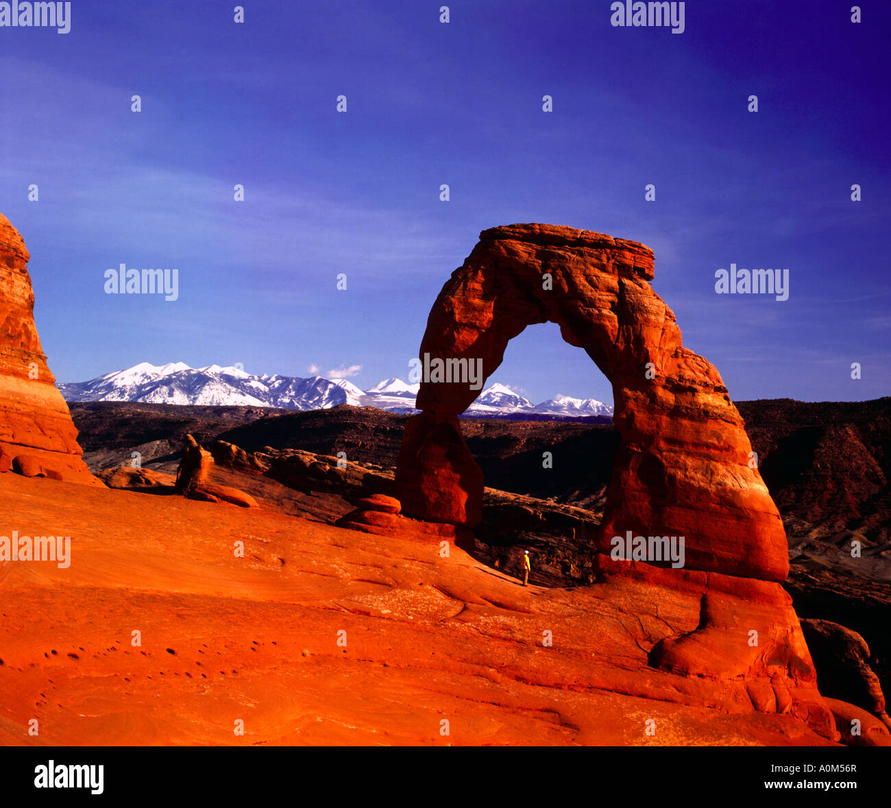 Einsamer Wanderer steht unter der imposanten Felsformation der Delicate Arch im Arches National Park in der Nähe von Moab in Utah Stockfoto