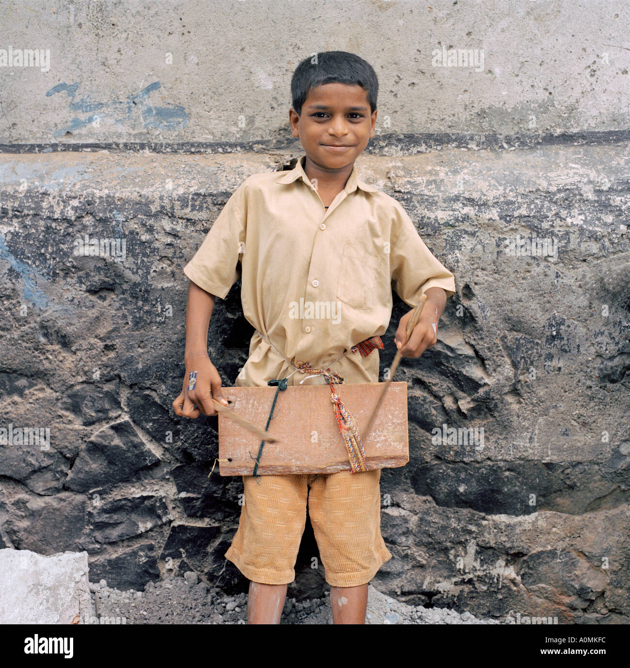 Junge in einem Slum genießen, spielen einer Trommel aus aus recycelten Materialien gefunden in der Nähe Mumbai Indien Stockfoto