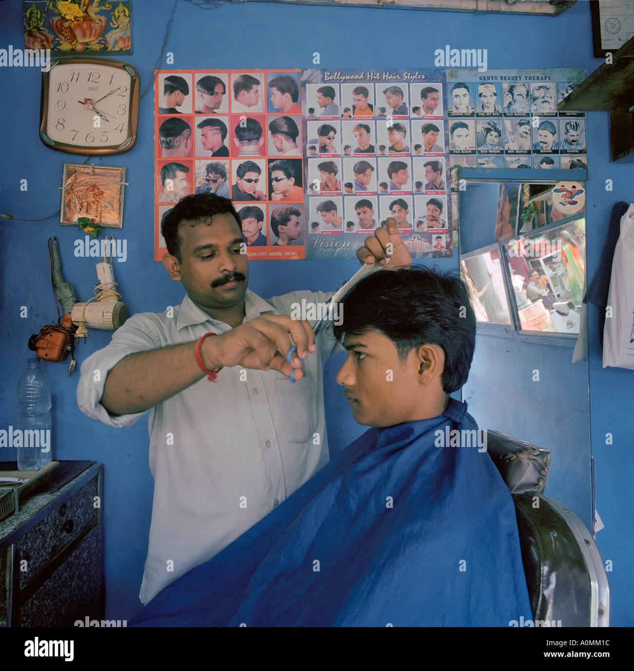 RVA92592 Ein Haar schneiden Salon in einem Slum mit Charts der beliebtesten Frisuren oft geschmückt mit Bollywood-Stars Mumbai Indien Stockfoto