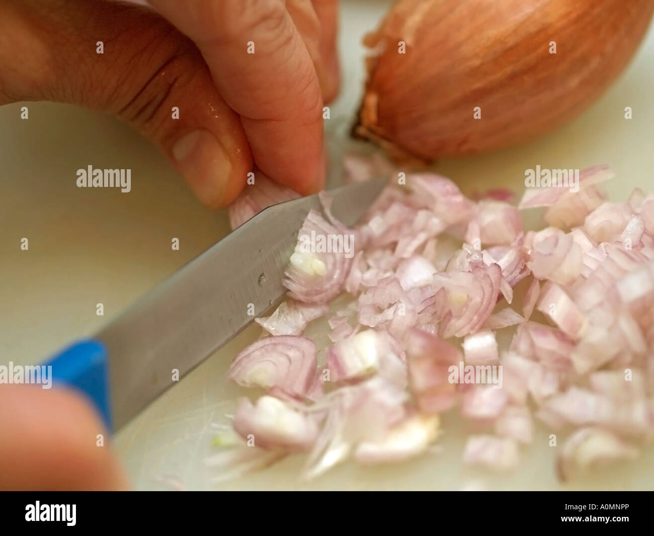 die Hand schneiden Zwiebel in kleine Stücke Stockfoto