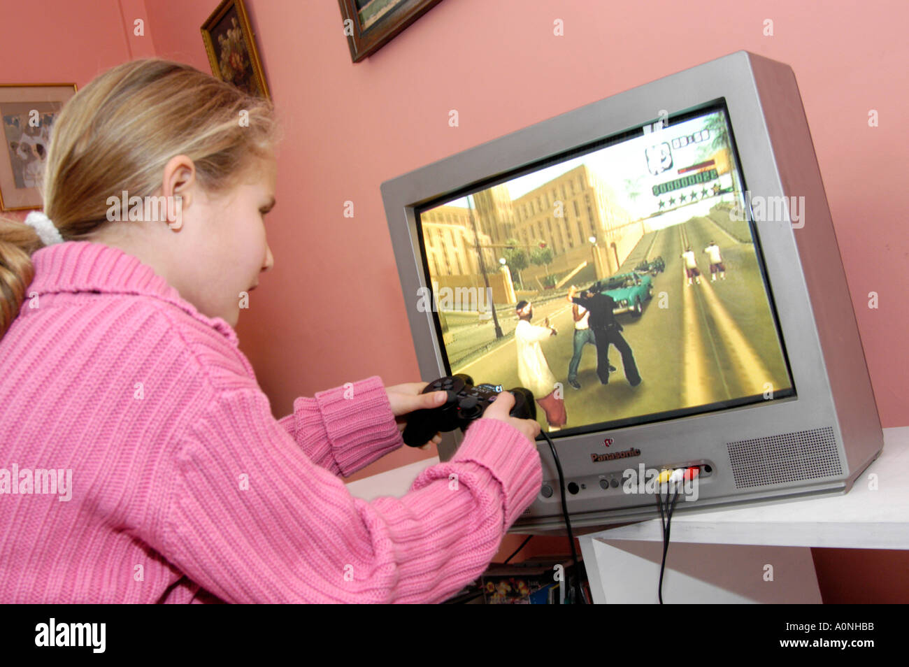 Junge Mädchen spielen gewalttätige 18 Zertifikat bewertet Computerspiel Grand Theft Auto auf Sony Playstation Konsole, England, UK Stockfoto