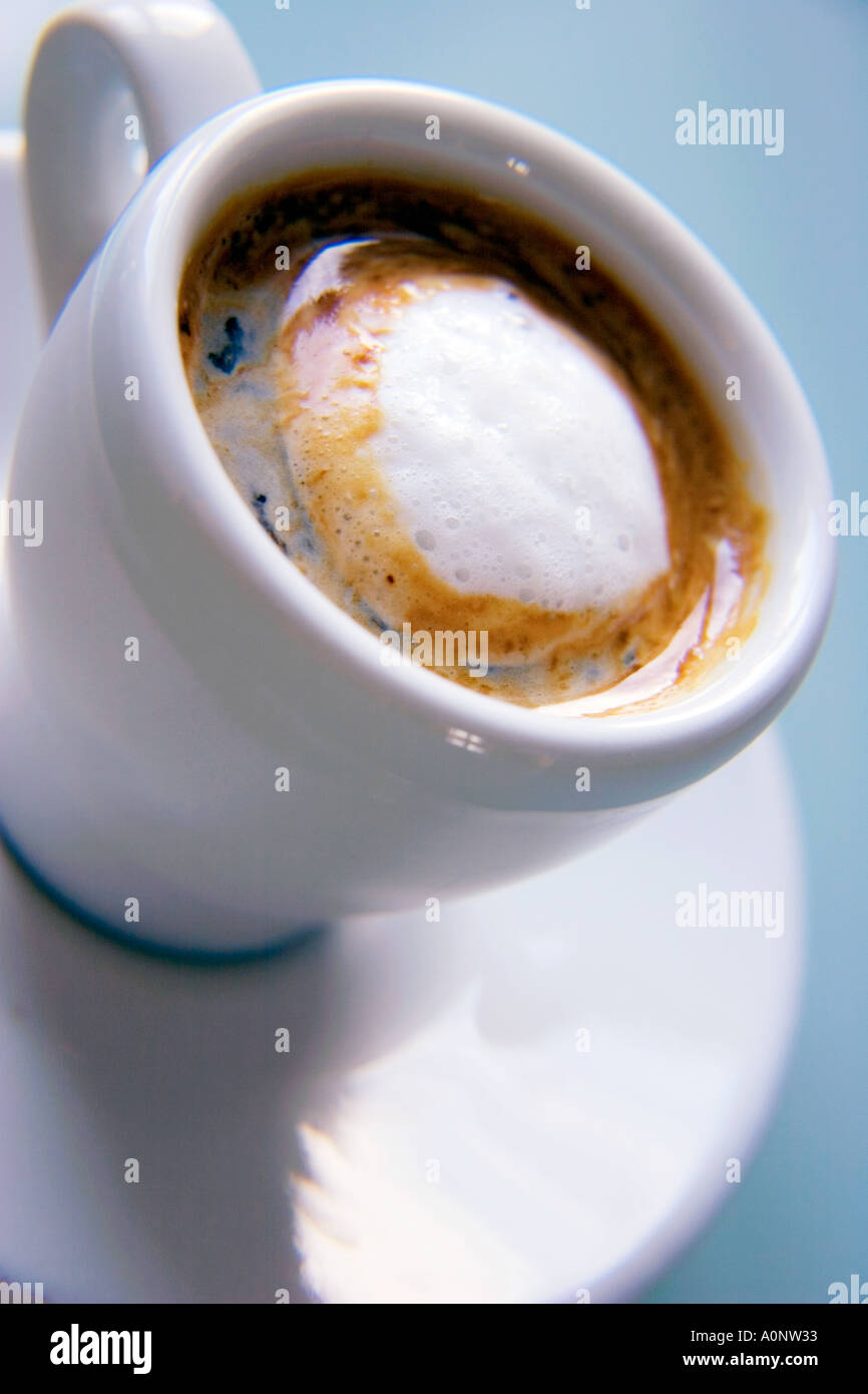 Weiße Espressotasse und Untertasse mit frisch zubereiteten Kaffee auf einem Winkel fotografiert Stockfoto