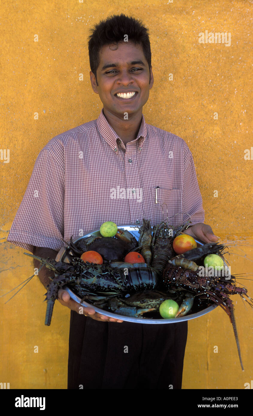 Ein Kellner hält einen Teller mit Meeresfrüchten serviert in vielen Restaurants rund um den Strand Hikkaduwa Sri Lanka Stockfoto