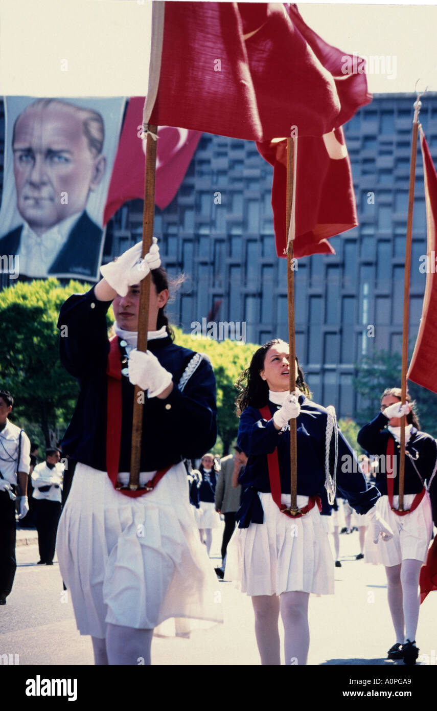 Junge türkische Mädchen auf Parade mit türkischen Fahnen mit einem Poster von Mustafa Kemal Atatürk Looking Down auf sie - Taksım Sq Stockfoto